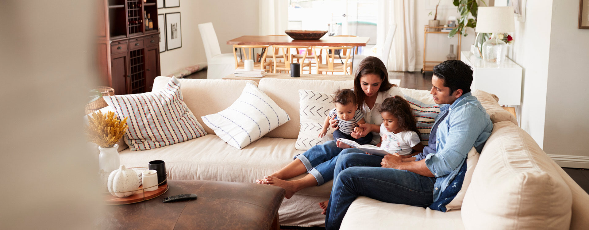 iStock-1094435430-1920×750-XL Family reading book in comfortable home